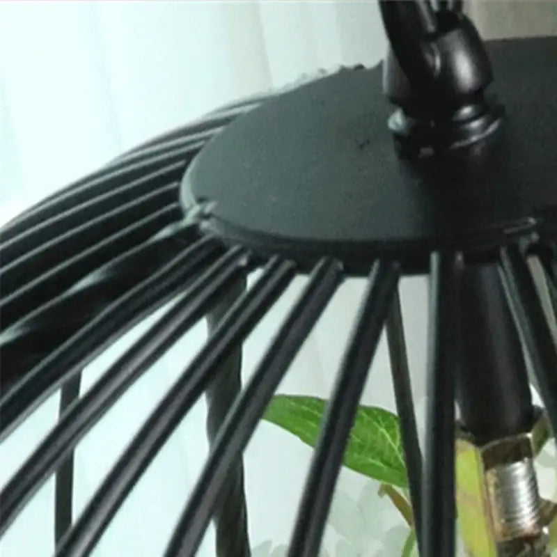 Black metal cage with slender vertical bars and circular top mount in decorbites industrial style rose chandelier pendant