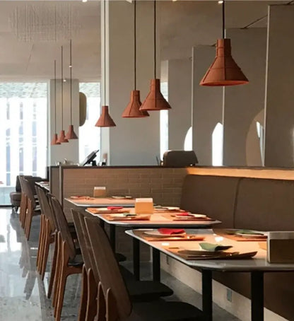 Industrial terracotta cement pendant lamp with conical shades hanging in dining room by decorbites cement pendant