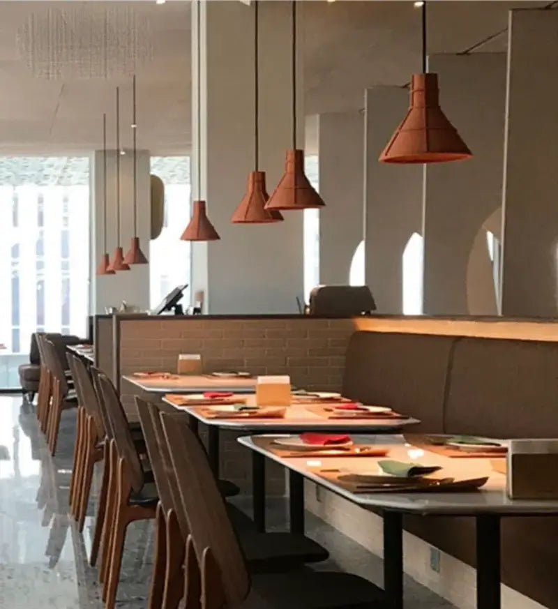 Industrial terracotta cement pendant lamp with conical shades hanging in dining room by decorbites cement pendant