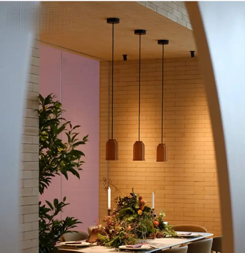 Three warm-toned bell-shaped industrial terracotta cement pendant lamps by decorbites for dining room lighting