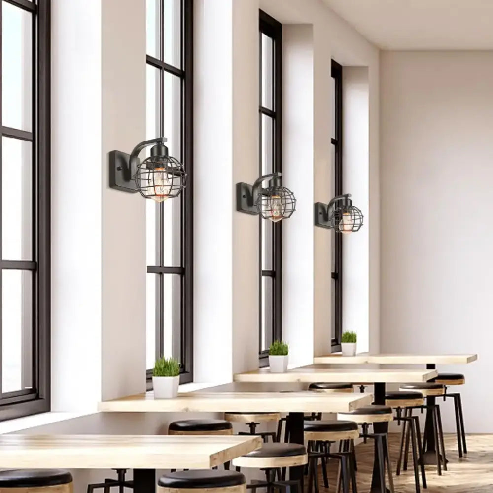 Industrial vintage black iron cage wall light featuring a black metal wire cage and exposed filament bulb by decorbites