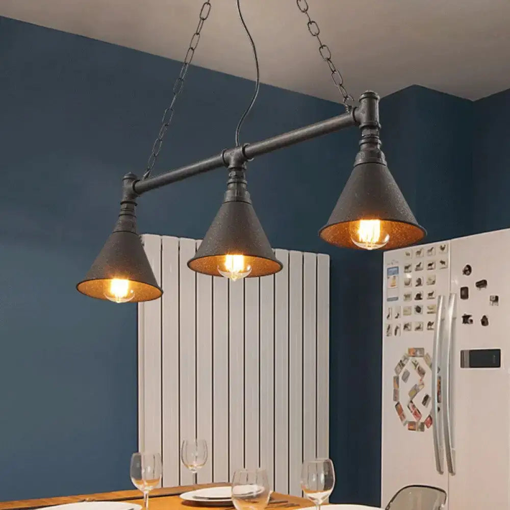 Industrial black metal pendant light with three conical shades and exposed bulbs for rust-coloured island lighting
