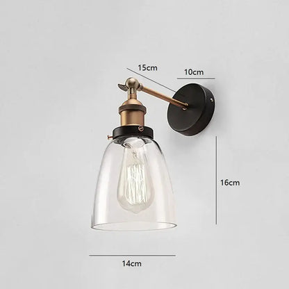 Industrial vintage loft wall lamp with brass arm, black base, clear glass bell shade, and exposed edison bulb for decorbites