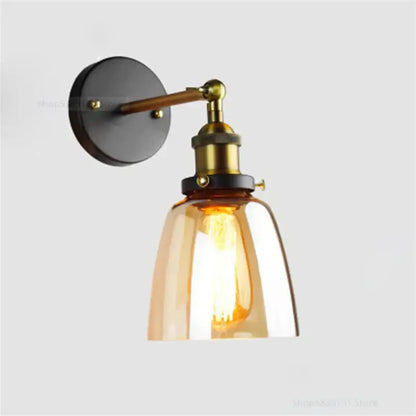 Vintage-style industrial vintage loft wall lamp with brass-finished metal arm and amber glass shade for bedroom decorbites