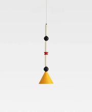A modern industrial vintage pendant light with yellow conical shade, white cylinders, and black spherical accents by decorbites
