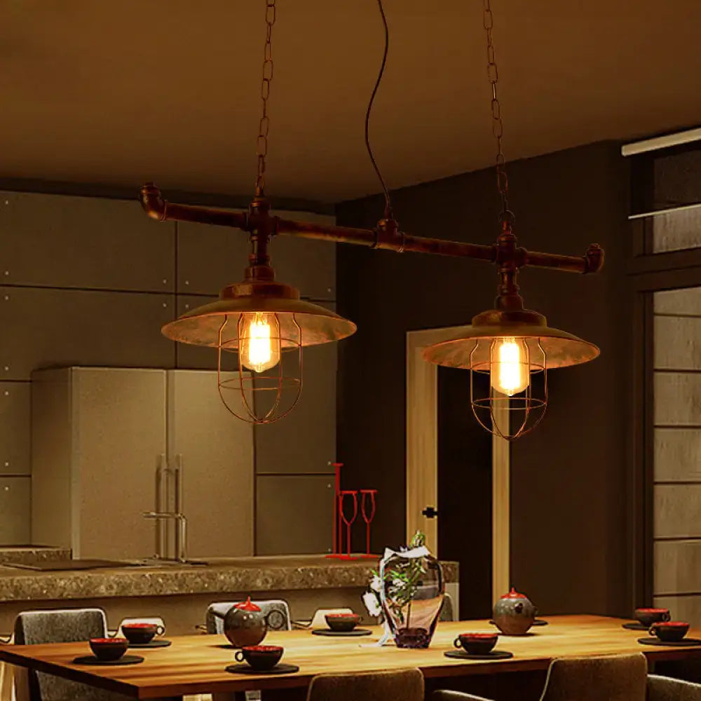 Industrial-style pendant lights with weathered copper pipe design and metal cage shades hanging by chain cord length