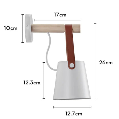 Industrial white and brass wall sconce with white ceramic lamp, light wood arm, and brown leather strap for decorbites industrial led lighting