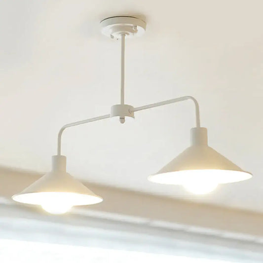 White industrial-style DecorBites pendant light with two conical shades and curved angle arm for kitchen island lighting