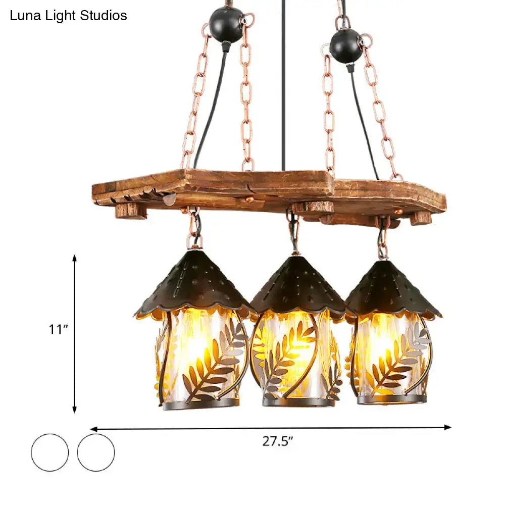 Rustic wooden chandelier with three amber glass lanterns featuring leaf cutouts and dark metal roofs for industrial white clear lantern island lighting