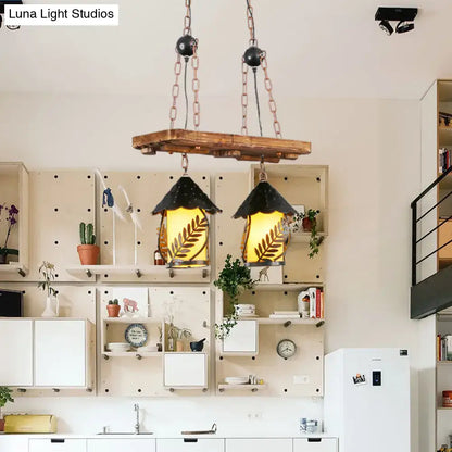Rustic wooden beam pendant light with two black conical shades featuring leaf designs and warm yellow glass panels for industrial white clear lantern island lighting
