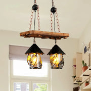 Rustic wooden plank with copper chains and two black and amber industrial white clear lantern island lighting fixtures