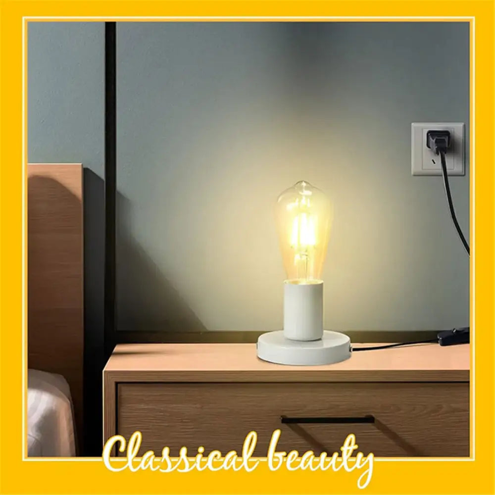 A warm glowing industrial white table lamp base with clear glass bulb and ceramic decorbites industrial white design