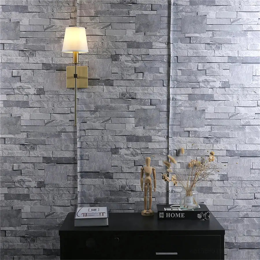 Gold-toned wall lamp with a soft white cylindrical lampshade for decorbites industrial white wall bathroom use