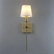A sleek industrial white wall lamp with a brass finish and cylindrical fabric shade for bathroom decorbites industrial white