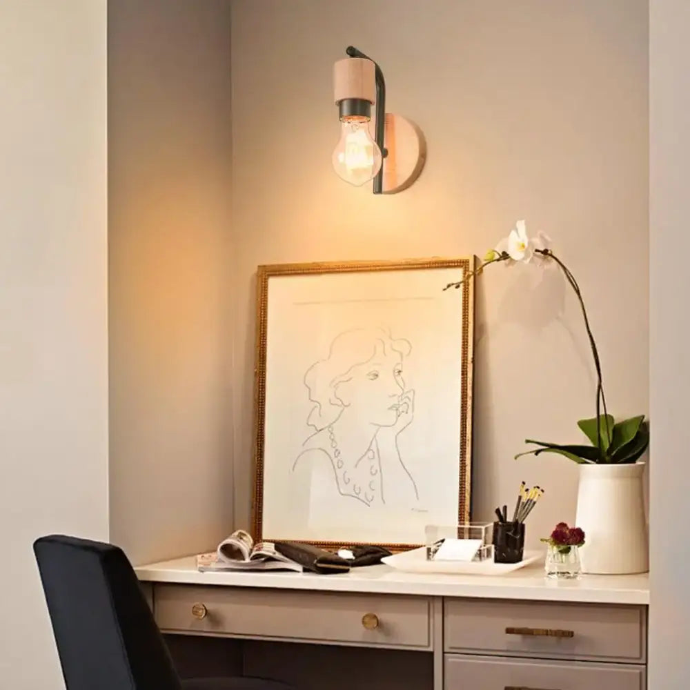 A warm-toned industrial wire cage wall sconce with a cylindrical wooden shade and exposed filament bulb for decorbites