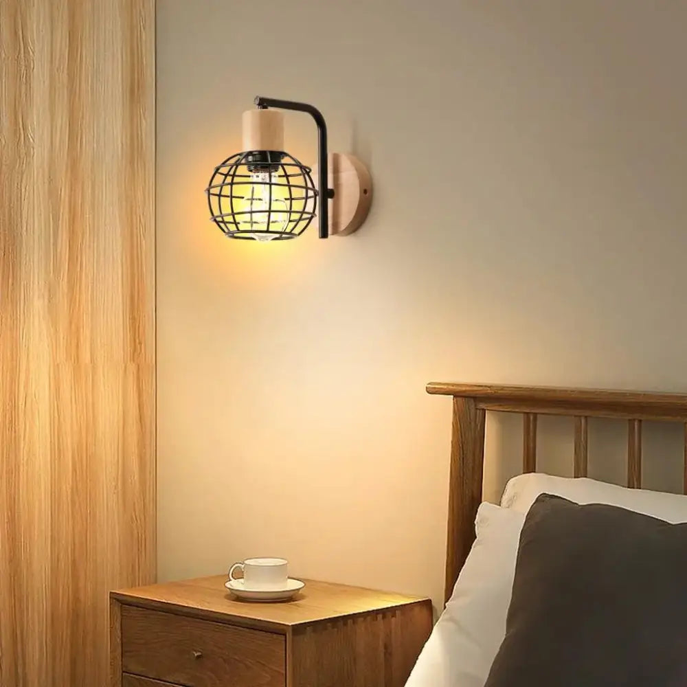 Industrial wire cage wall sconce with black metal cage, warm bulb, and natural wood backplate for bedroom decorbites industrial wire style