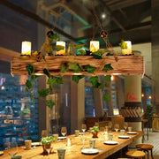 Industrial wood and ivy dining room chandelier featuring rustic wooden beam fixture width with four glowing e26 e27 pendant light candles and trailing green ivy vines