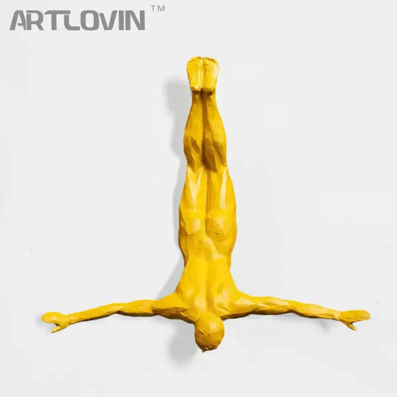 Industrial yellow bungee jumper wall sculpture featuring vibrant sculptural human figure in inverted pose for living room decorbites decor