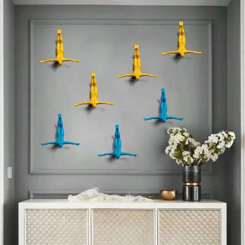 Six yellow and blue abstract human figures with outstretched arms industrial decorbites bungee jumper wall sculpture