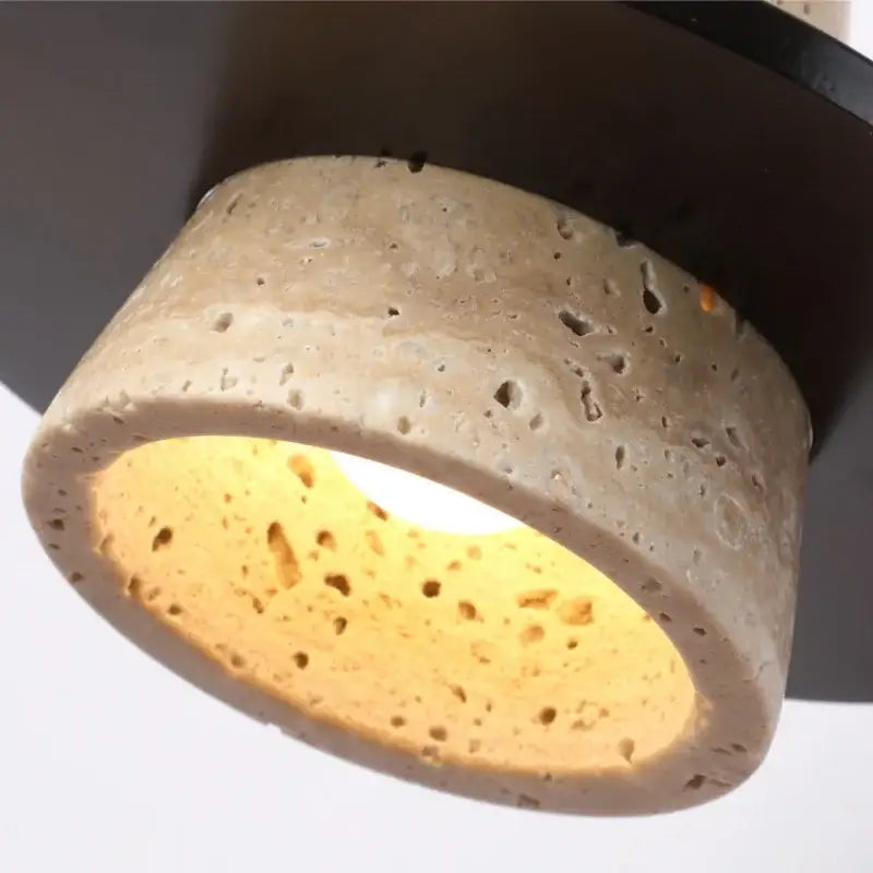 Rounded concrete wall lamp with beige textured exterior yellow travertine interior glow and pull chain switch for bedroom