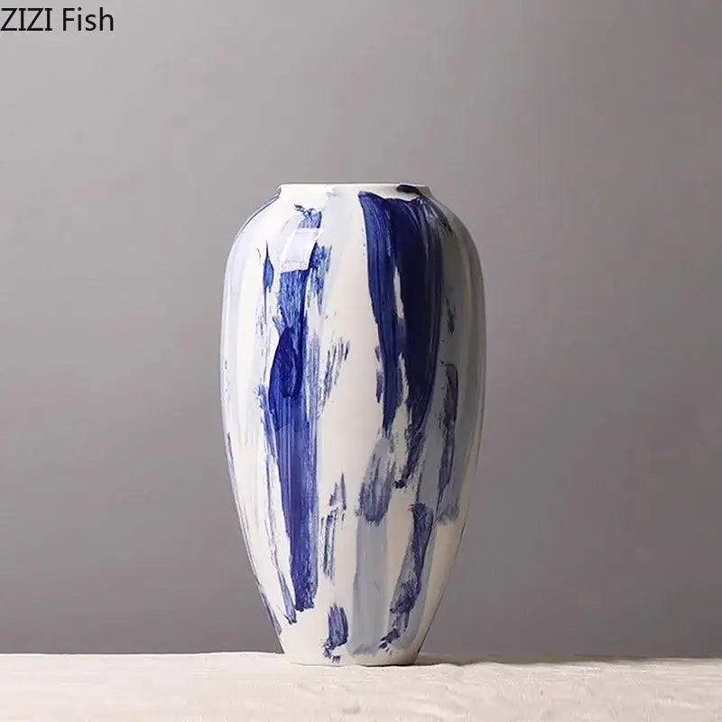 A white ceramic vase with bold abstract blue ink style brushstroke patterns for living room decor