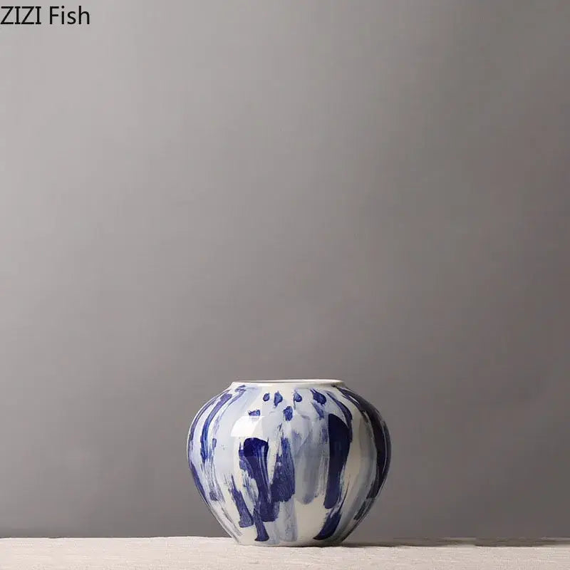 A hand-painted blue and white ceramic vase with abstract ink style brushstroke patterns for living room decor