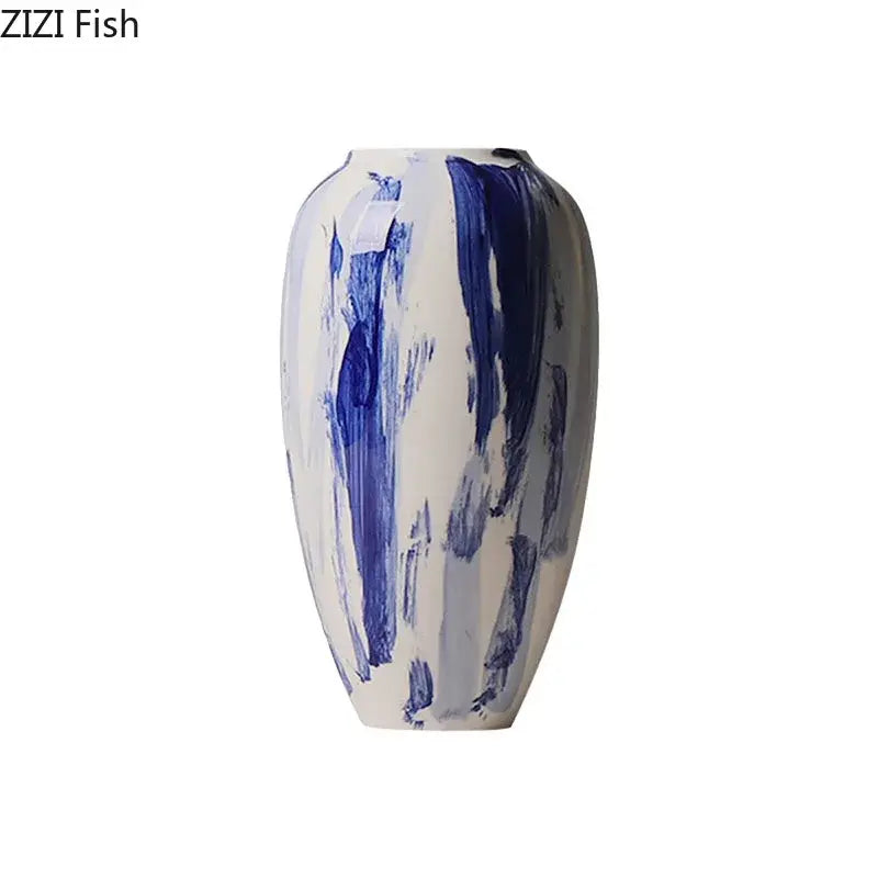 A sleek white ceramic vase with bold abstract blue ink style brushstrokes for living room decor
