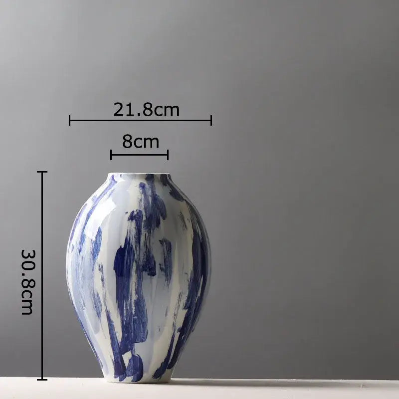 A sleek hand-painted ceramic vase with bold blue ink style brushstroke patterns on a white base for living room decor