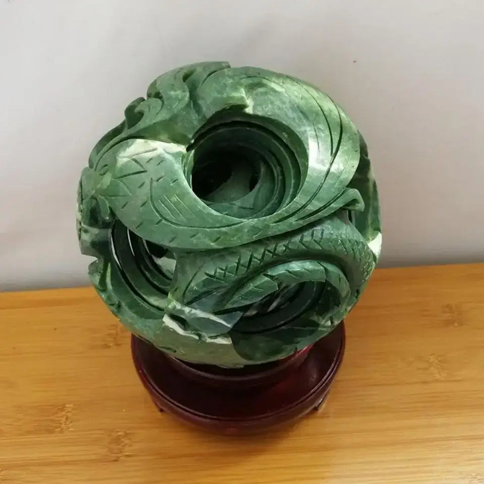 Intricate green jade stone dragon phoenix ball featuring a coiled dragon design on a polished wooden stand for living room decor