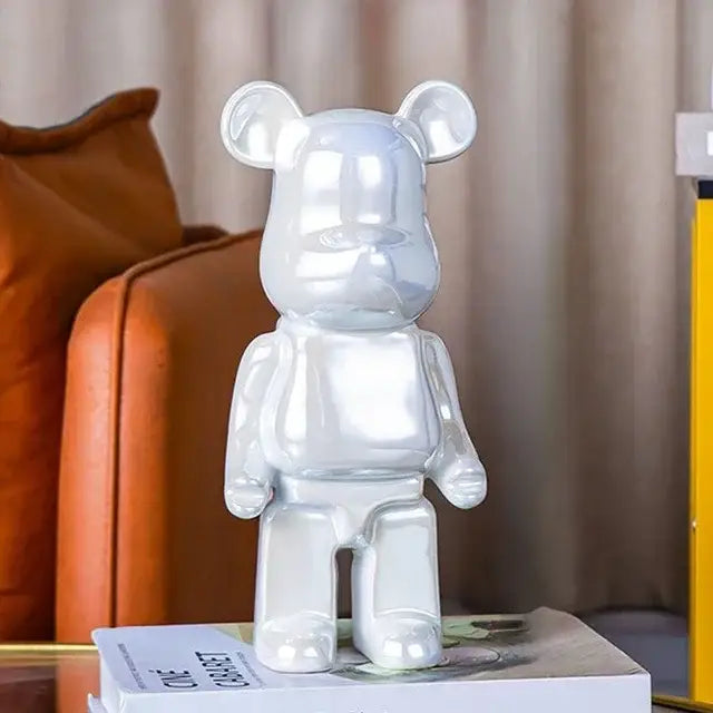 Shiny silver metallic bear piggy bank with glossy reflective surface as cabinet sculpture decor for living room