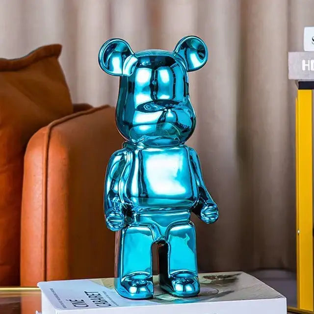 A glossy turquoise metallic bear piggy bank with a sleek reflective surface perfect for cabinet sculpture decor