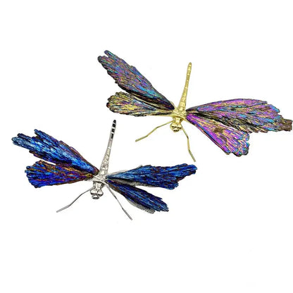 Two iridescent decorative figurines featuring crystal dragonfly designs with gold and silver bodies in blue and purple hues