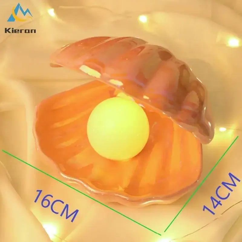 Iridescent ceramic shell pearl led night light with translucent orange and pink finish and glowing yellow pearl inside