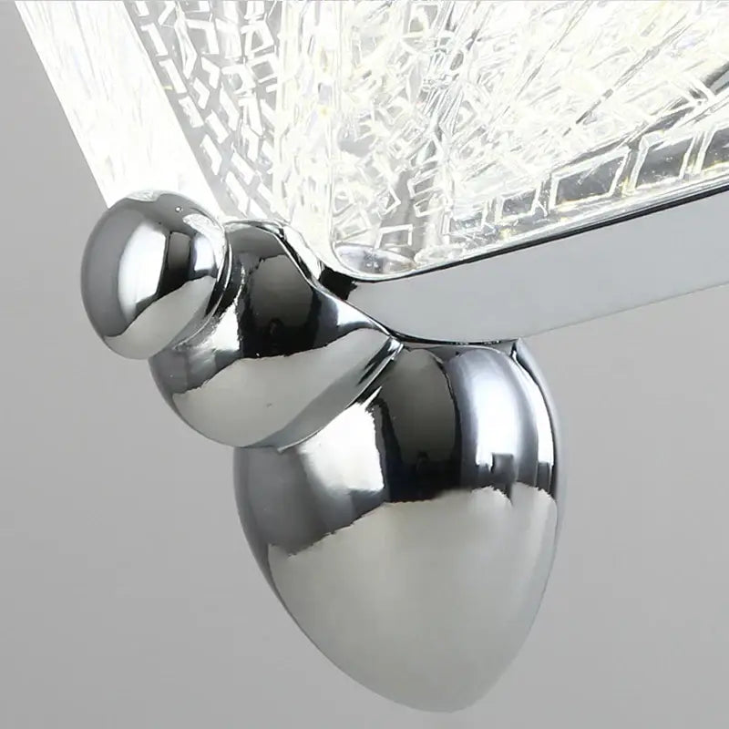 Chrome finished acorn shaped wall sconce with textured crystal glass shade complements decorbites butterfly pendant lights