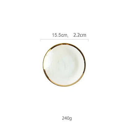 A small white ceramic salad bowl with a delicate gold rim complementing iridescent gold rim glass salad bowl tableware