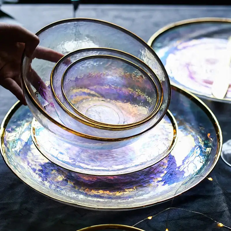 Set of iridescent glass salad bowls with gold rims stacked on matching plates for elegant dining room tableware