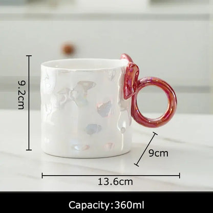 White ceramic coffee mug with iridescent bowknot glazed finish and pinkish-red ring handle by decorbites bowknot glazed