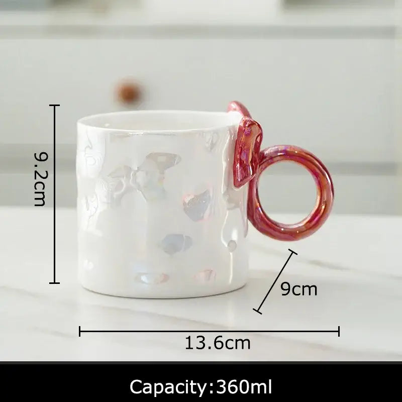 White ceramic coffee mug with iridescent bowknot glazed finish and pinkish-red ring handle by decorbites bowknot glazed