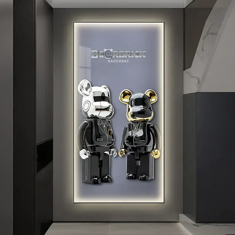 Two glossy silver and gold bearbrick figures in black suits displayed against an iron man led wall lamp for bedroom decor