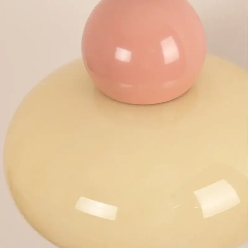 A smooth glossy peach iron nordic led wall light on a rounded pale yellow base with pull chain for bedroom decorbites wall light