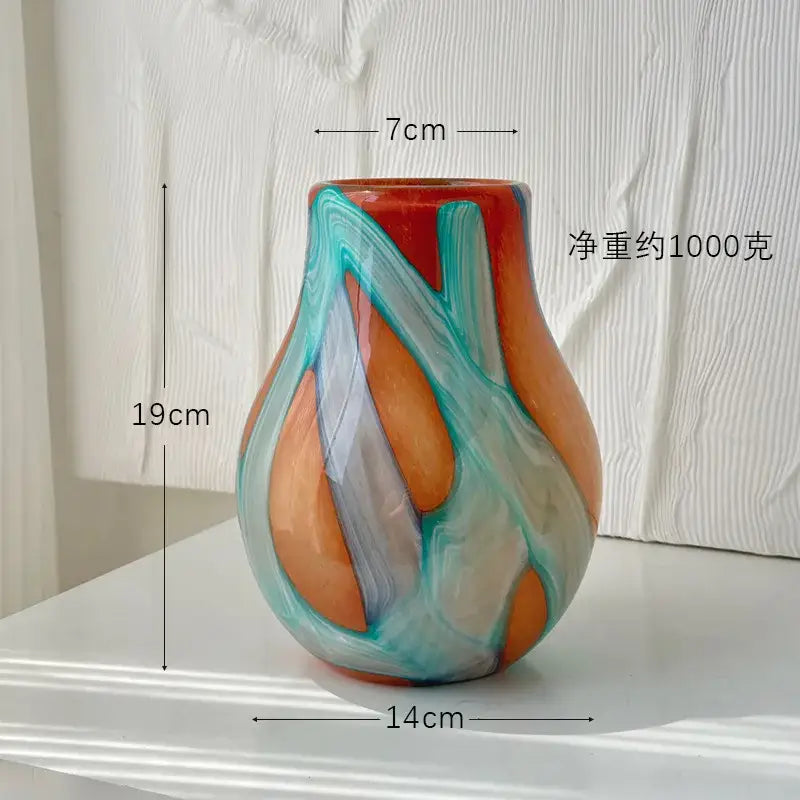 A vibrant hand-blown glass vase with irregular geometric graffiti patterns in orange teal and gray for decorbites decor