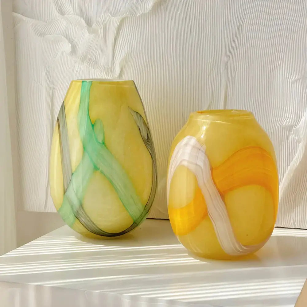 Two hand-blown glass vases with swirling yellow green and white patterns showcasing irregular geometric graffiti decorbites style