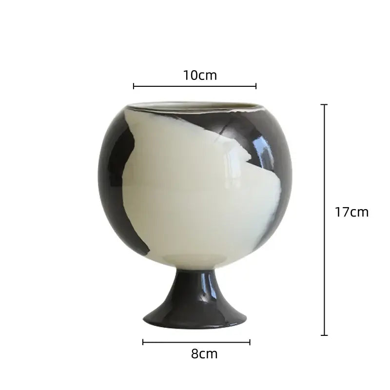 A glossy black and white ceramic irregular grain spherical vase with an asymmetrical body for living room decor