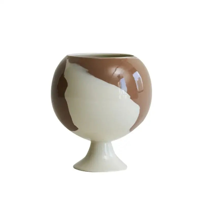 A glossy ceramic pedestal vase with an irregular grain spherical shape in brown and cream for living room decorbites decor