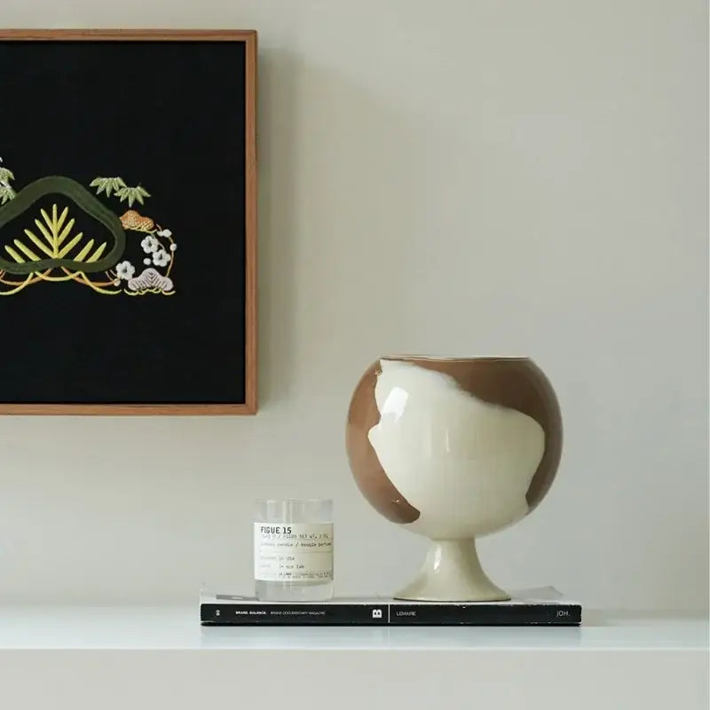 A glossy two-toned ceramic irregular grain spherical vase in cream and brown decorbites irregular grain decor