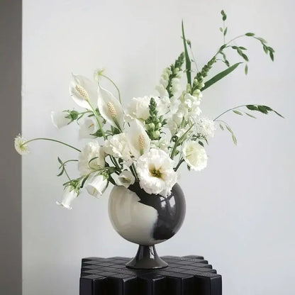 A sleek black and white ceramic irregular grain spherical vase with calla lilies for living room decorbites decor