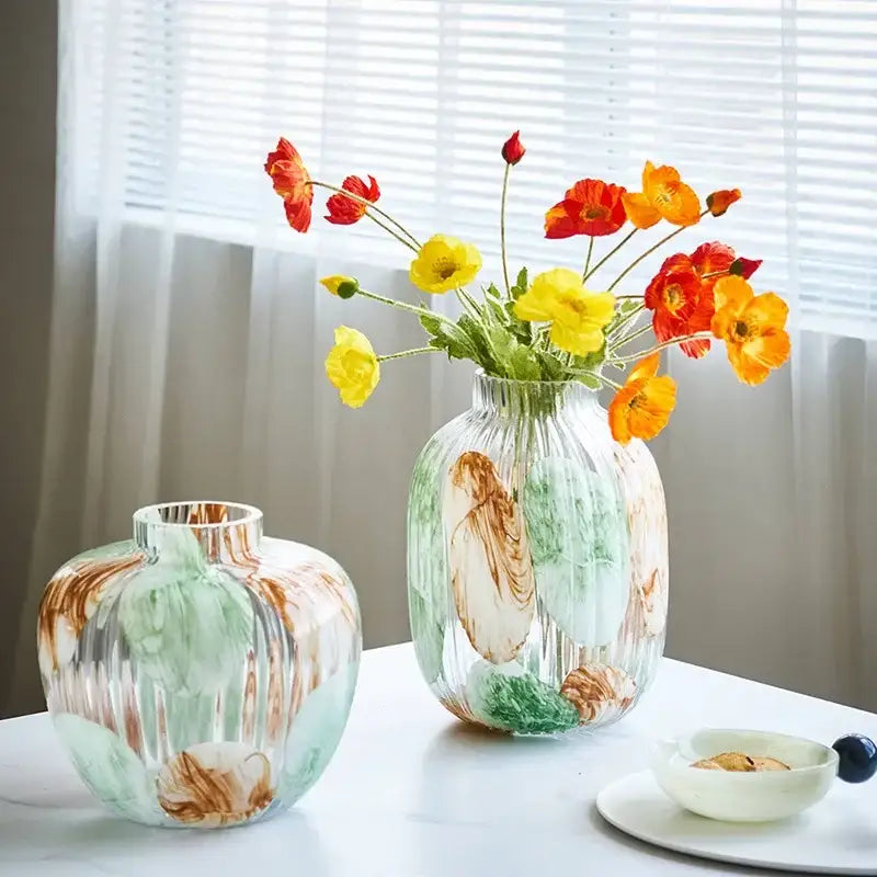Irregular ribbed green and brown decorbites clear glass vase with swirling marbled pattern holding vibrant poppies for living room decor