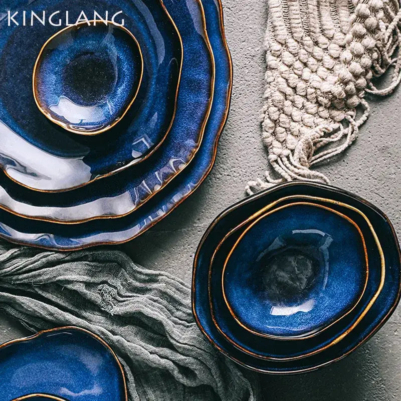 Deep cobalt blue ceramic dinner set with irregular shape and gold-rimmed edges by decorbites for dining room use