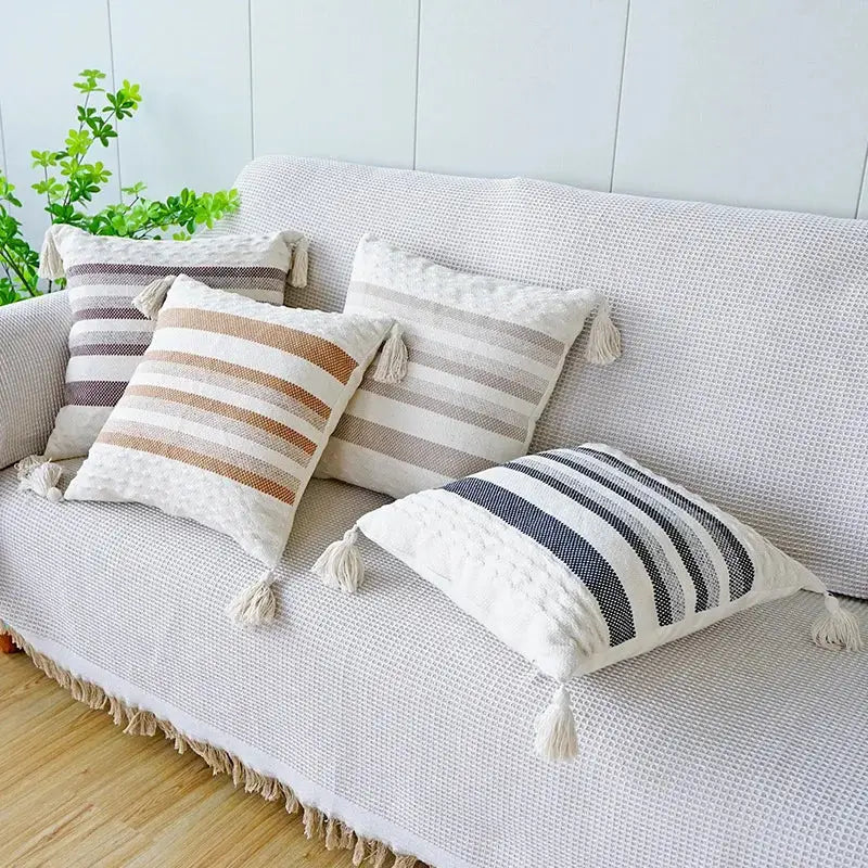 Four ivory brown coffee striped pillow cases with woven texture and tassels on a white sofa for decorbites decorbites ivory brown decor