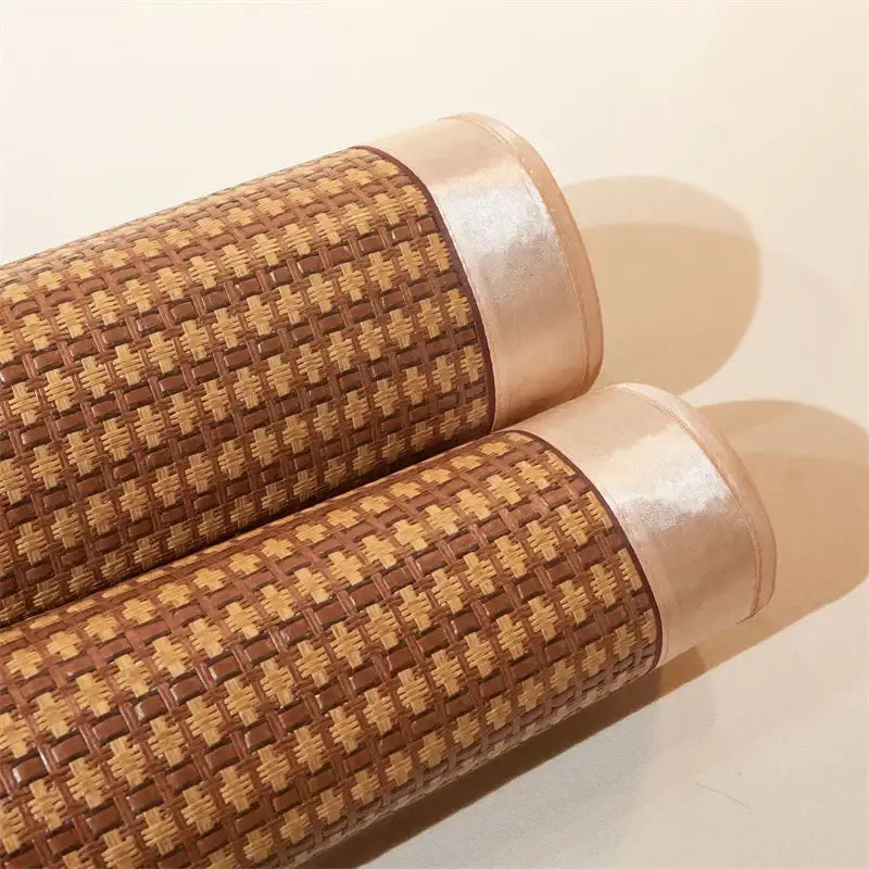 Two rolled decorbites jacquard cool brown and cream woven rattan cooling mats with shiny beige ribbon edges for bedroom decor